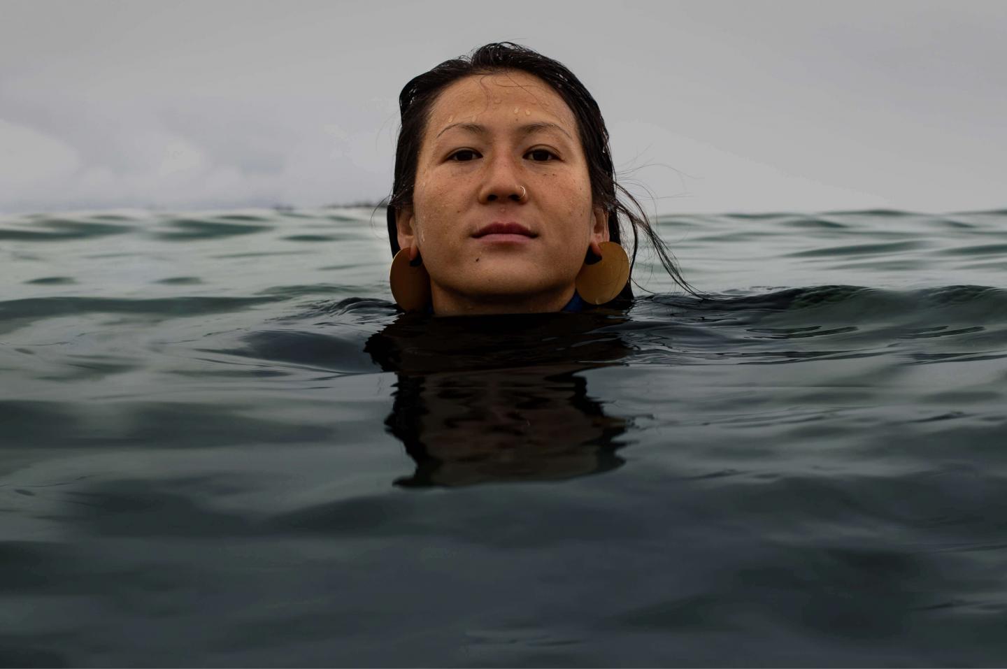 Women with her body submerged in the ocean
