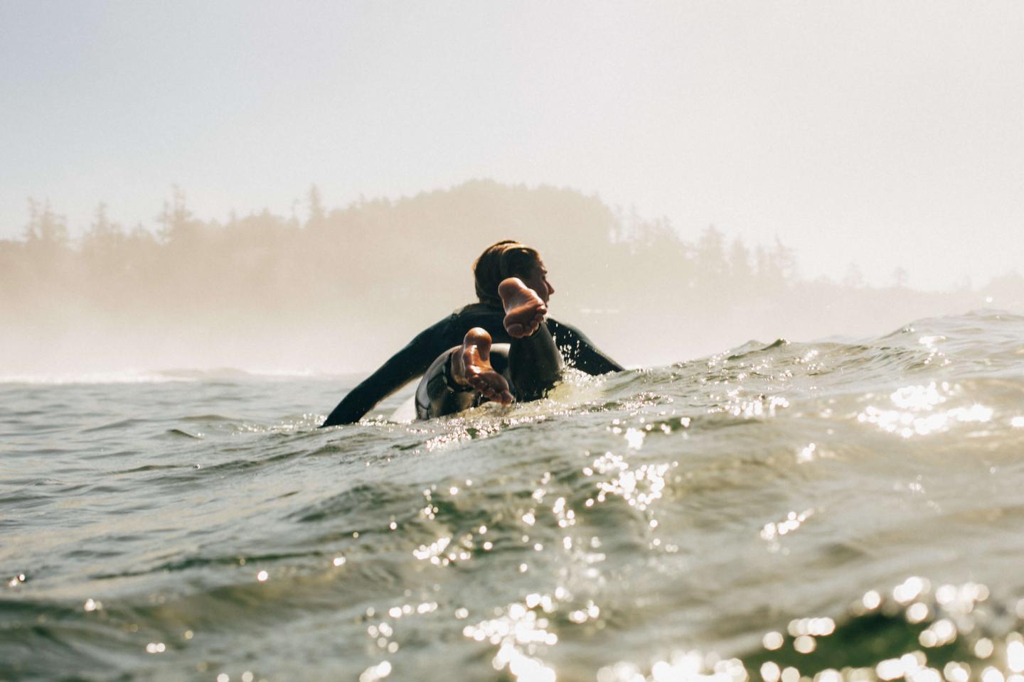 Surfer paddling away from camera